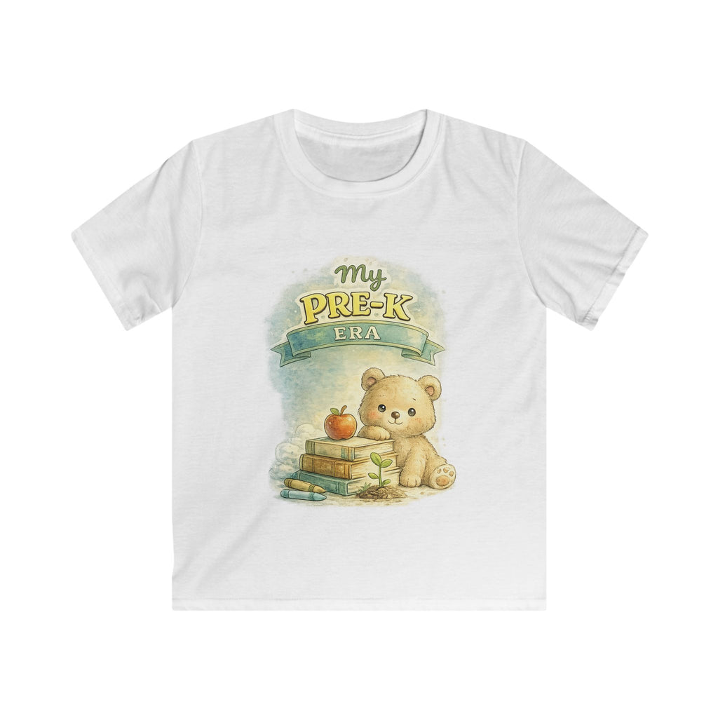 A white short-sleeve crewneck t-shirt featuring a cute cartoon graphic of a teddy bear sitting next to books and an apple, with the text 'My PRE-K FRA' above it.